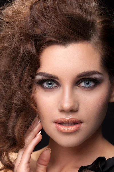 Portrait a brunette woman hairstyle curls on a black background — Stock Photo, Image