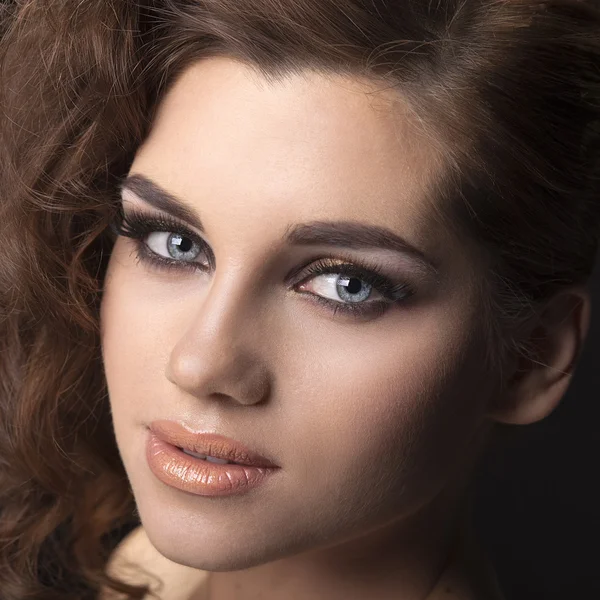 Portrait a brunette woman hairstyle curls on a black background — Stock Photo, Image