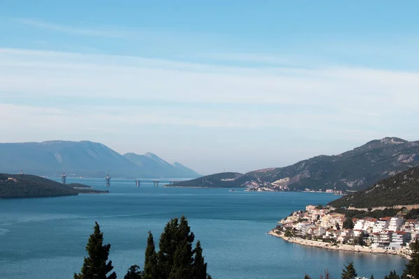 Hırvatistan 'da inşa edilen ve Peljesac adasını Hırvatistan anakarasına bağlayan, Bosna Neum bölgesini çevreleyen uzak bir köprü manzarası. Neum kasabası önplanda görünür