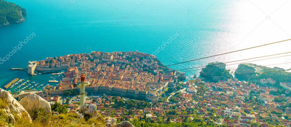 Wide panorama view of the Dubrovnik city, old town and the surrounding area seen from above from the Srd mountain, cablecar wire going towards the city