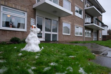 Cambridge 'deki küçük bir yerleşim yerinin bahçesinde eriyen küçük çirkin bir kardan adam. 2020 yılının ilk karı ve çocuklar bu küçük heykelleri yaparken eğleniyorlar.