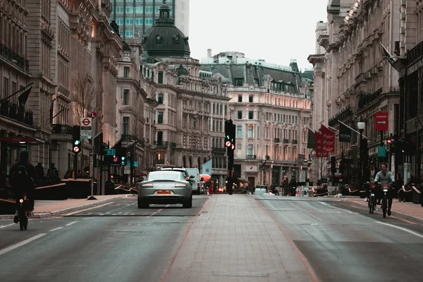 Londra Birleşik Devletleri Şubat 2021 UKs ulusal tecrit sırasında Londra sokaklarının görüntüsü boş. Tek bir Aston Martin birkaç bisikletçiyle uzaklardan geçiyor.