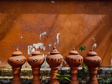 Kahverengi beton duvarlı toprak kap.