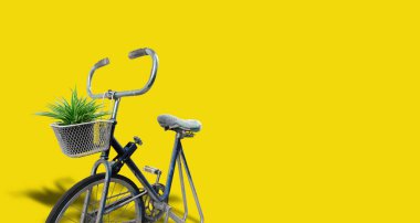 Eski bir bisikletin bir saksıya dönüştürülmesinin ön görüntüsü, sarı arka planda izole edilmiş, ücretsiz fotokopi alanı olan klasik bir dekorasyon olarak gösterilir..