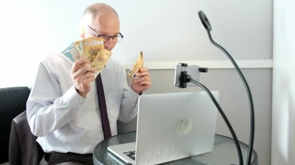 Caucasian man 45 - 50 years old, talking on a conference call. Pulls out money. — Stock Video