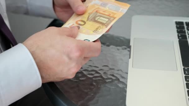 Um homem caucasiano ganhou dinheiro na Internet. Contagem de notas de euro. — Vídeo de Stock