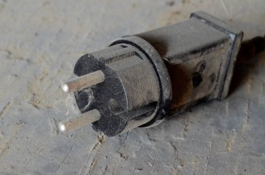 Ahşap bir yüzeydeki toz tabakası için geniş siyah plastik priz