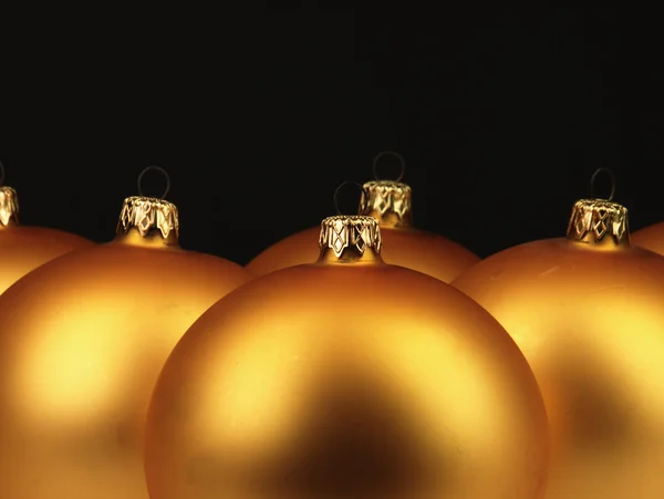Grote gouden kerstballen op zwarte achtergrond. — Stockfoto