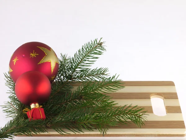 Bola de Navidad, ramita de pino y tabla de cortar . — Foto de Stock