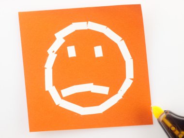 Üzgün bir yüz sembolü ile yapışkan not.