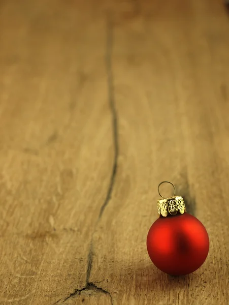 Bola roja de Navidad sobre un fondo de roble de madera . —  Fotos de Stock
