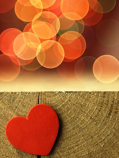 Ahşap bir masa kenarında kırmızı kalp.