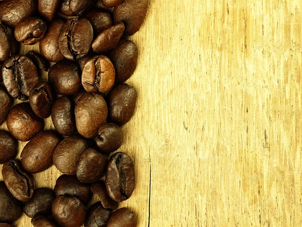 Kaffebönor närbild på trä, ek bord. — Stockfoto