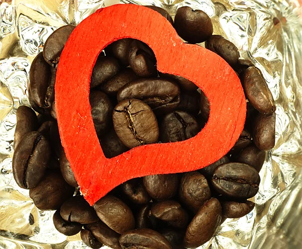 Hjärta och kaffebönor närbild på trä, ek bord. — Stockfoto