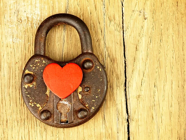 Rusty padlock and heart on a wooden background. — Stock Photo, Image