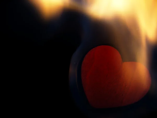 Cuore fiammeggiante su sfondo nero . — Foto Stock