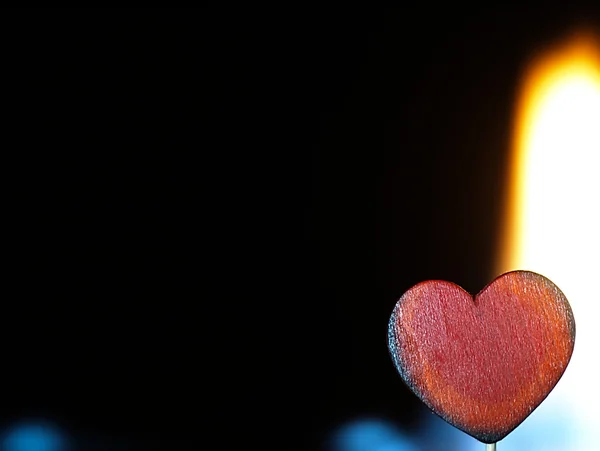 Corazón en llamas sobre un fondo negro . — Foto de Stock