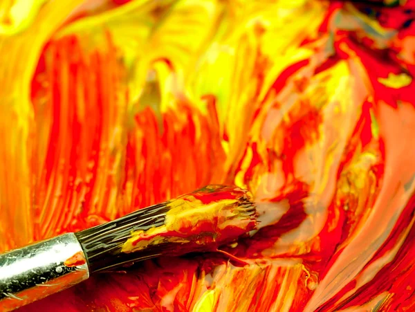 Colored paint mixed on palette. Dirty brush in the foreground. — Stock Photo, Image