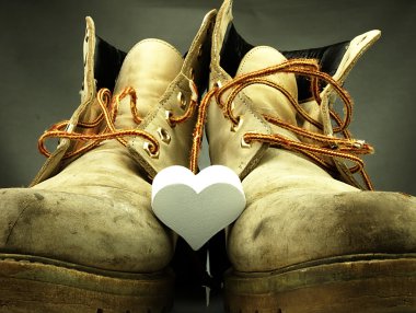 Pair of heavy military boots and white heart. clipart