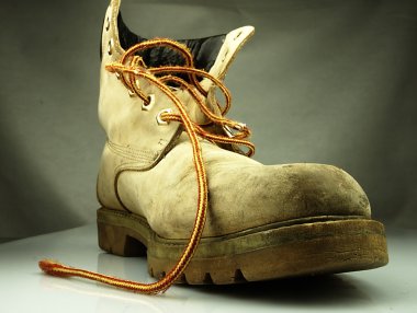 Military boot. Old heavy and destroyed. clipart