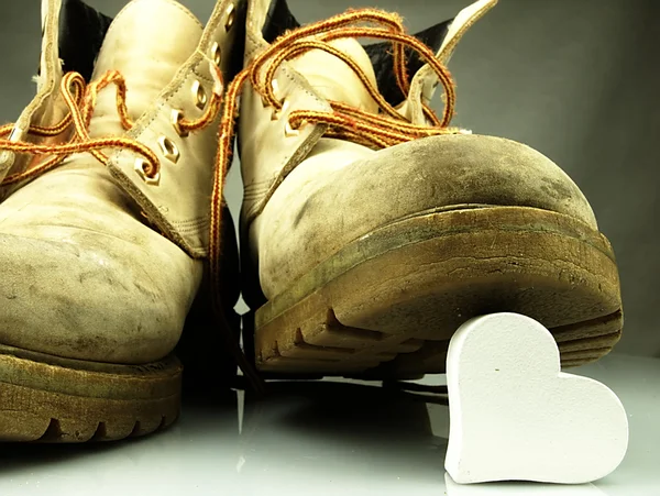 Botas militares pesadas pisoteando coração . — Fotografia de Stock