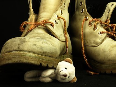 Teddy bear crushed by a heavy, old military boot. clipart