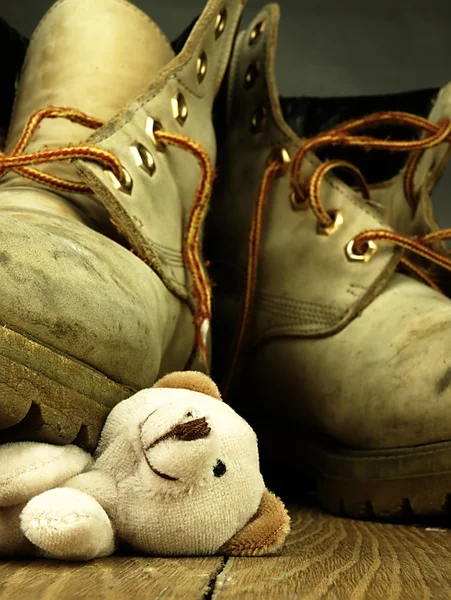 Urso de peluche esmagado por uma bota militar pesada e velha . — Fotografia de Stock