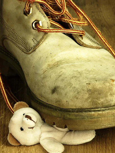 Urso de peluche esmagado por uma bota militar pesada e velha . — Fotografia de Stock