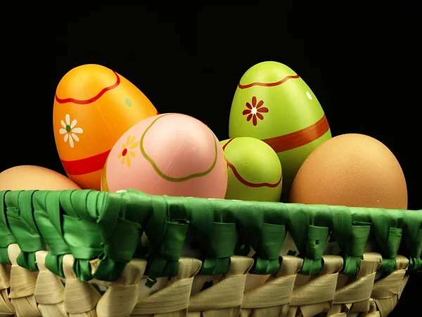 Coloridos huevos de Pascua en compañía de huevos ordinarios . —  Fotos de Stock