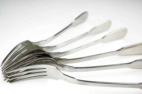 Forks arranged in series on the kitchen table. Stock Photo