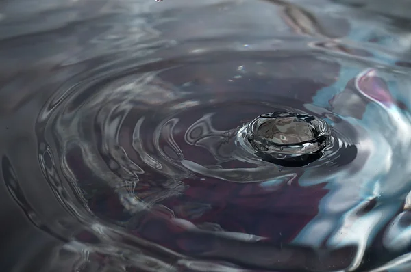 Une goutte d'eau éclaboussée crée des vagues . — Photo