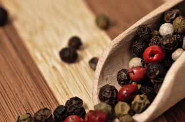 Bir ahşap tahta üzerinde renkli biber taneleri.