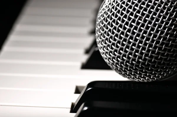 Microfoon op een piano toetsenbord. Stockfoto