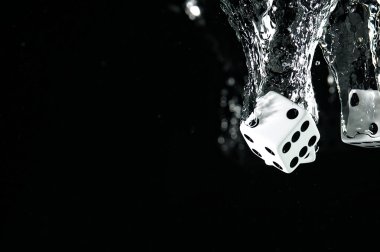 Suya düşen zar. Siyah bir arka plan üzerinde.