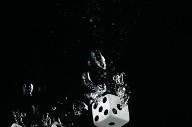 Suya düşen zar. Siyah bir arka plan üzerinde.