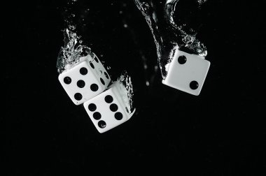 Suya düşen zar. Siyah bir arka plan üzerinde.