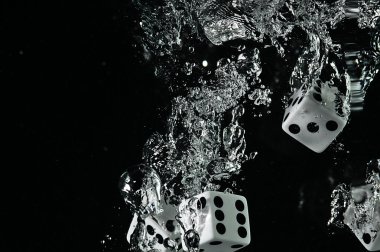 Suya düşen zar. Siyah bir arka plan üzerinde.