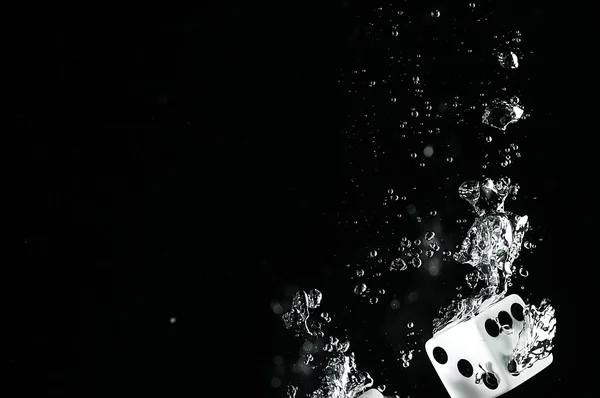 Tärningarna falla i vattnet. På svart bakgrund. — Stockfoto