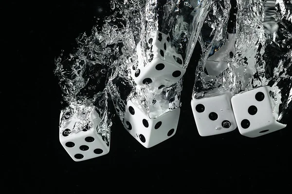 Suya düşen zar. Siyah bir arka plan üzerinde.