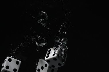 Suya düşen zar. Siyah bir arka plan üzerinde.