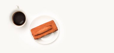 black coffee with a piece of chocolate cake, top view with copy space
