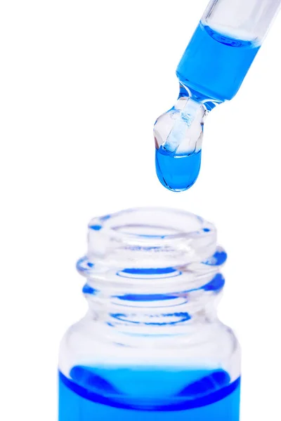 Макрос Піпетки Блакитною Рідиною Впасти Неї Скляна Пляшка Ізольована Білому — стокове фото