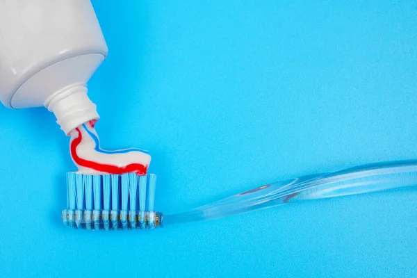 Primer Plano Apretar Pasta Dientes Cepillo Dientes Sobre Fondo Azul — Foto de Stock