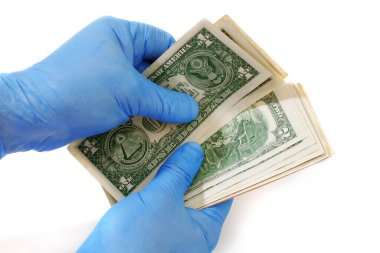 Tıbbi eldiven takan eller beyaz arka planda izole edilmiş dolar banknotlarını sayıyor