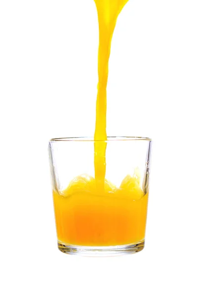 白い背景に隔離されたガラスにオレンジジュースを注ぎ — ストック写真