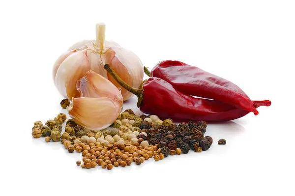 garlic, dry chili peppers, green black and white peppercorns and coriander isolated on white background