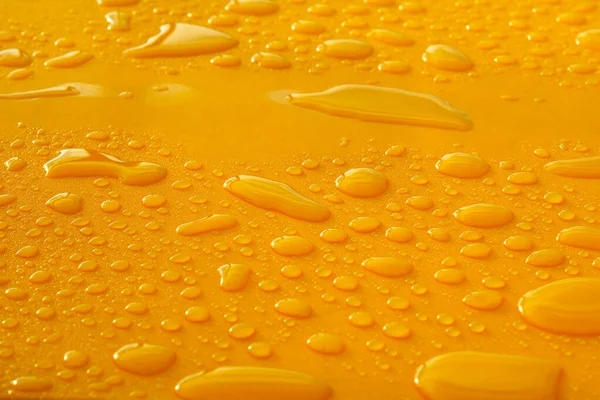 雨の後に平らな黄色の表面にランダムな水が落ち — ストック写真
