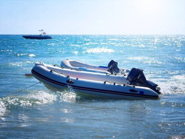 two inflatable boats with motors on a water clipart