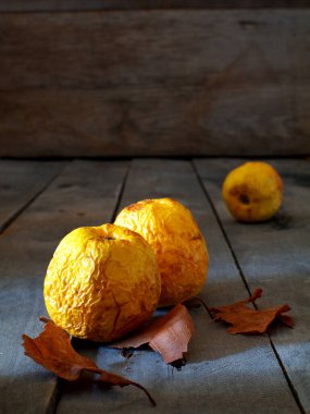 Kopya alanı olan tahta bir tahtanın üzerinde üç çürük elma.