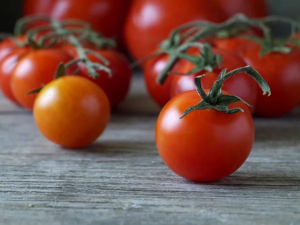 Reife Kirschtomate Vor Anderen Tomaten Auf Holztisch Geringe Schärfentiefe Nahaufnahme — Stockfoto